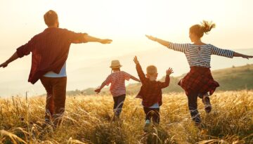 Happy family: mother, father, children son and daughter on sunset
